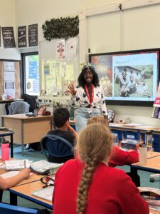 Storyteller Furaha Mussanzi speaks to students in a classroom.