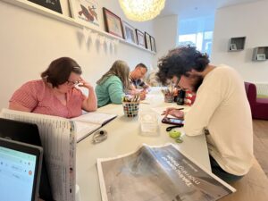 Members of the Word Out group working on their poems around a table.