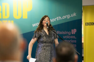 A member of the Word Out creative writing group performs on stage at BBC Contains Strong Language 2025.
