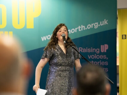 A member of the Word Out creative writing group performs on stage at BBC Contains Strong Language 2025.
